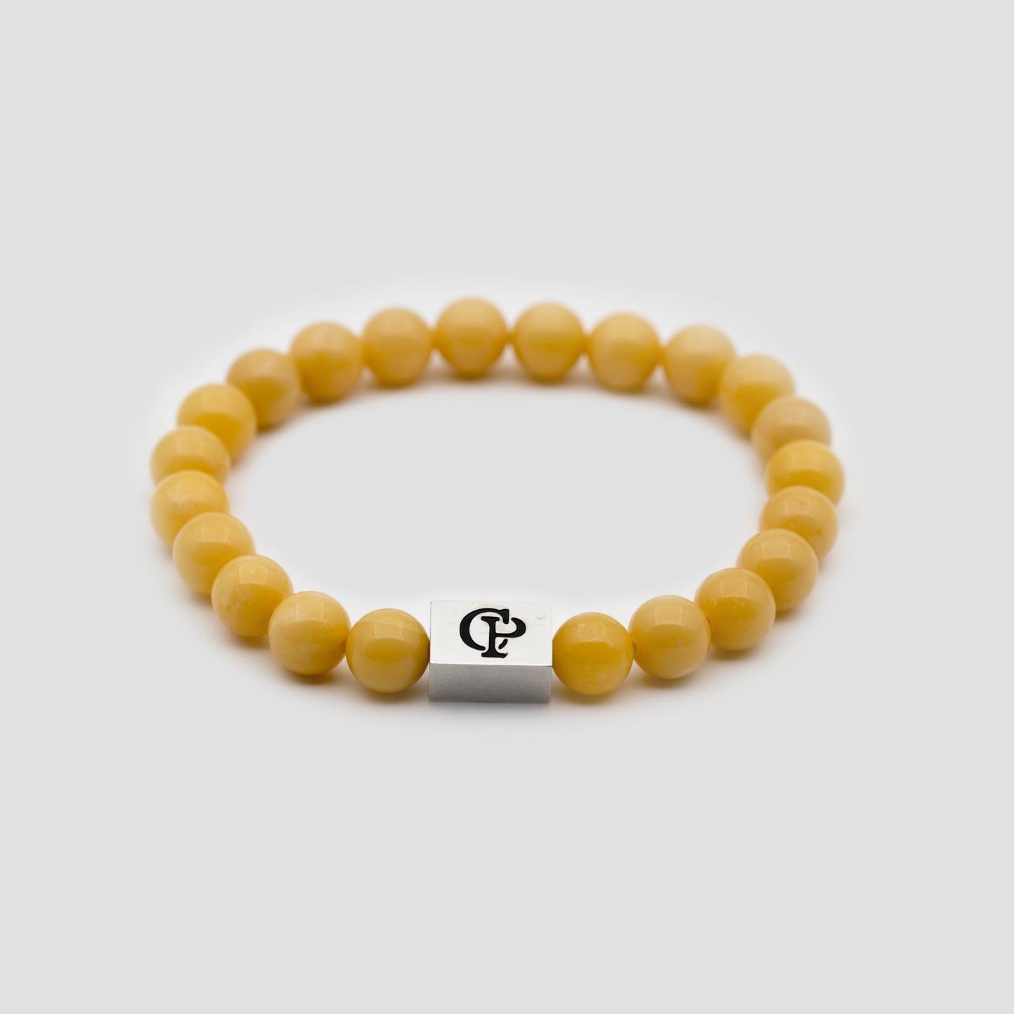 Yellow Jade Elastic Silver Bracelet on a gray surface