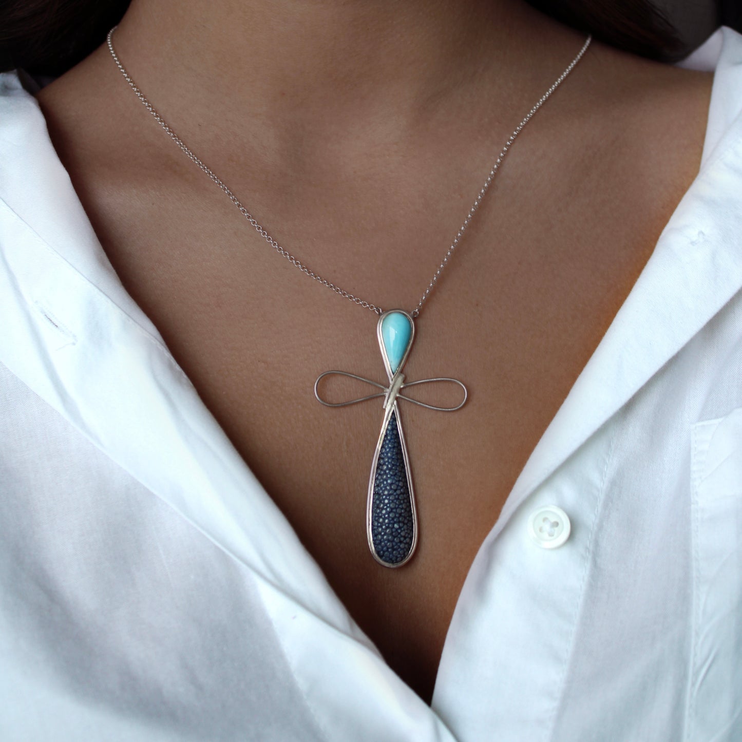 A woman wearing Larimar Stingray Skin Dragonfly Necklace