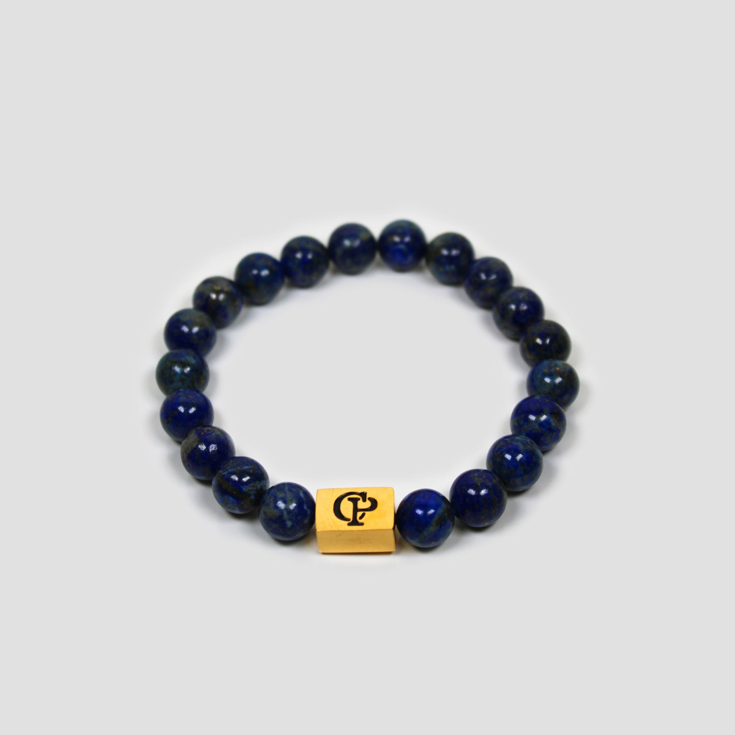 Blue Lapis Lazuli Elastic Golden Bracelet on a gray surface