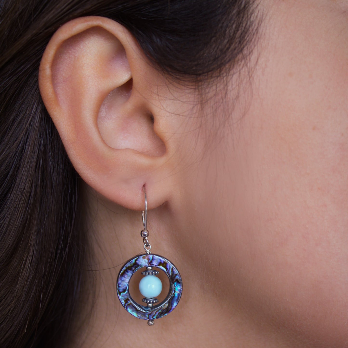 A woman wearing Larimar & Abalone Stability Earrings