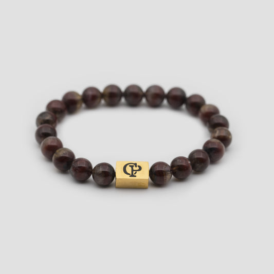 Brown Auralite Golden Elastic Bracelet on a gray surface