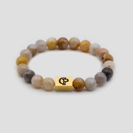 Multicolor Bamboo Leaf Agate Elastic Golden Bracelet on a gray surface