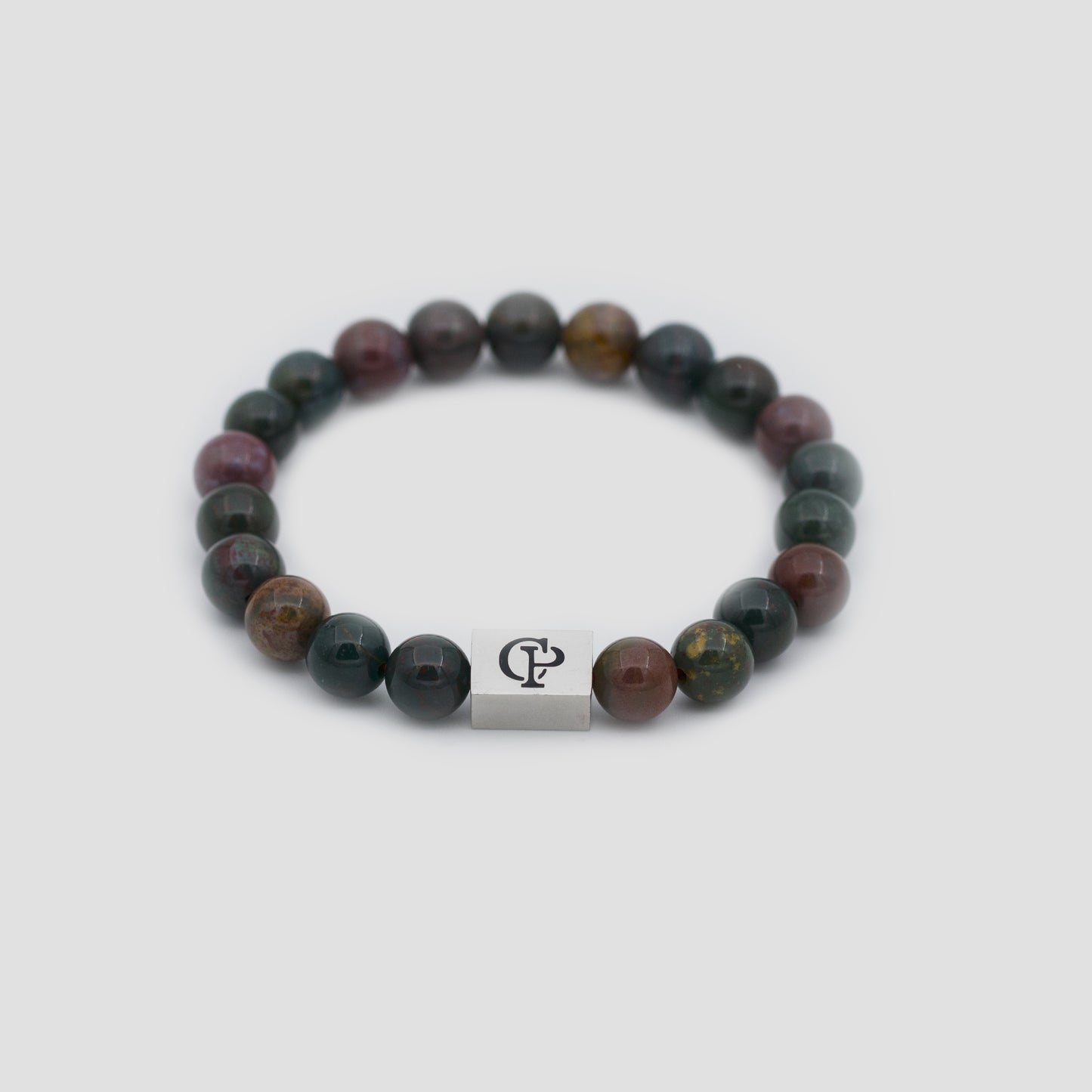 Red and Green Bloodstone Elastic Silver Bracelet on a gray surface