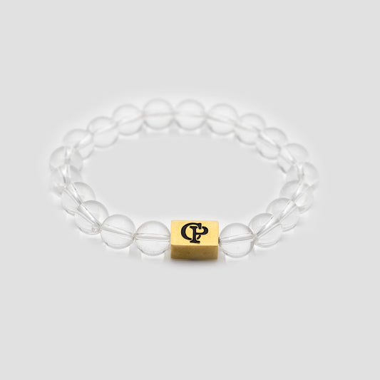 Crystal Quartz Elastic Golden Bracelet on a gray surface