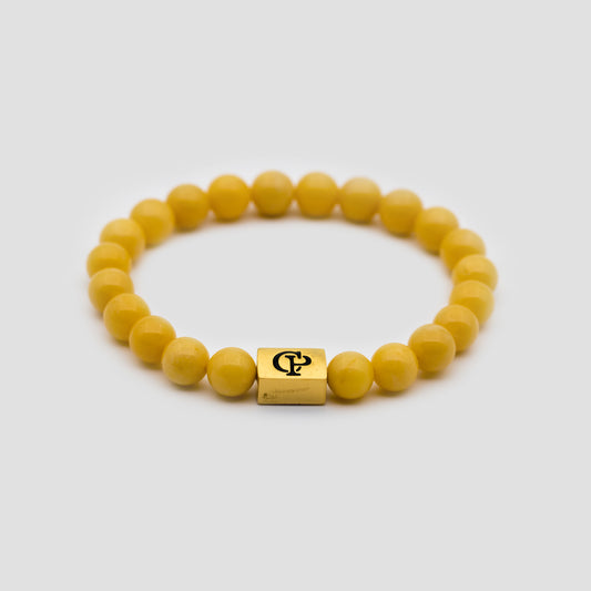 Yellow Jade Elastic Golden Bracelet on a gray surface
