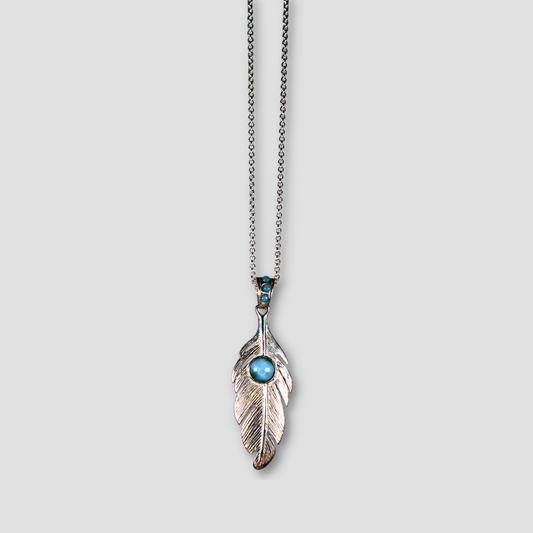 Light Blue Larimar Silver Feather Pendant on a gray surface