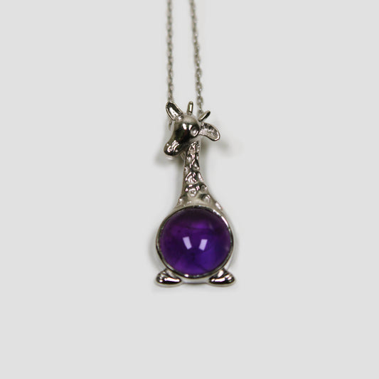 Purple Amethyst Giraffe with White Topaz Necklace on a gray surface