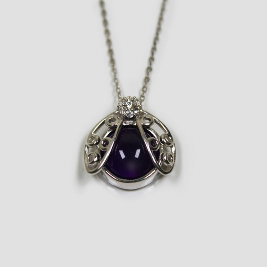 Purple Amethyst Ladybug with White Topaz Necklace on a gray surface