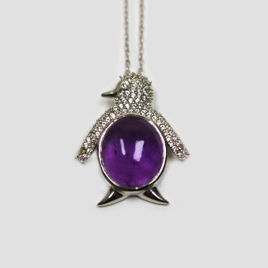 Purple Amethyst Penguin with White Topaz Necklace on a gray surface