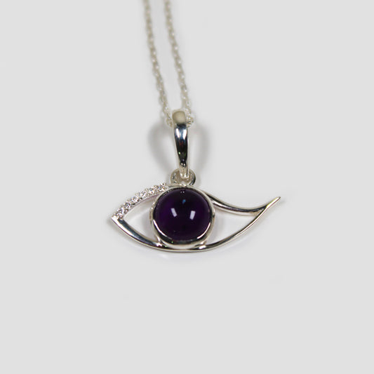 Amethyst Purple Ra Eye with White Topaz on a gray surface