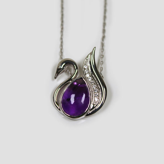 Purple Amethyst Swan with White Topaz Necklace on a gray surface