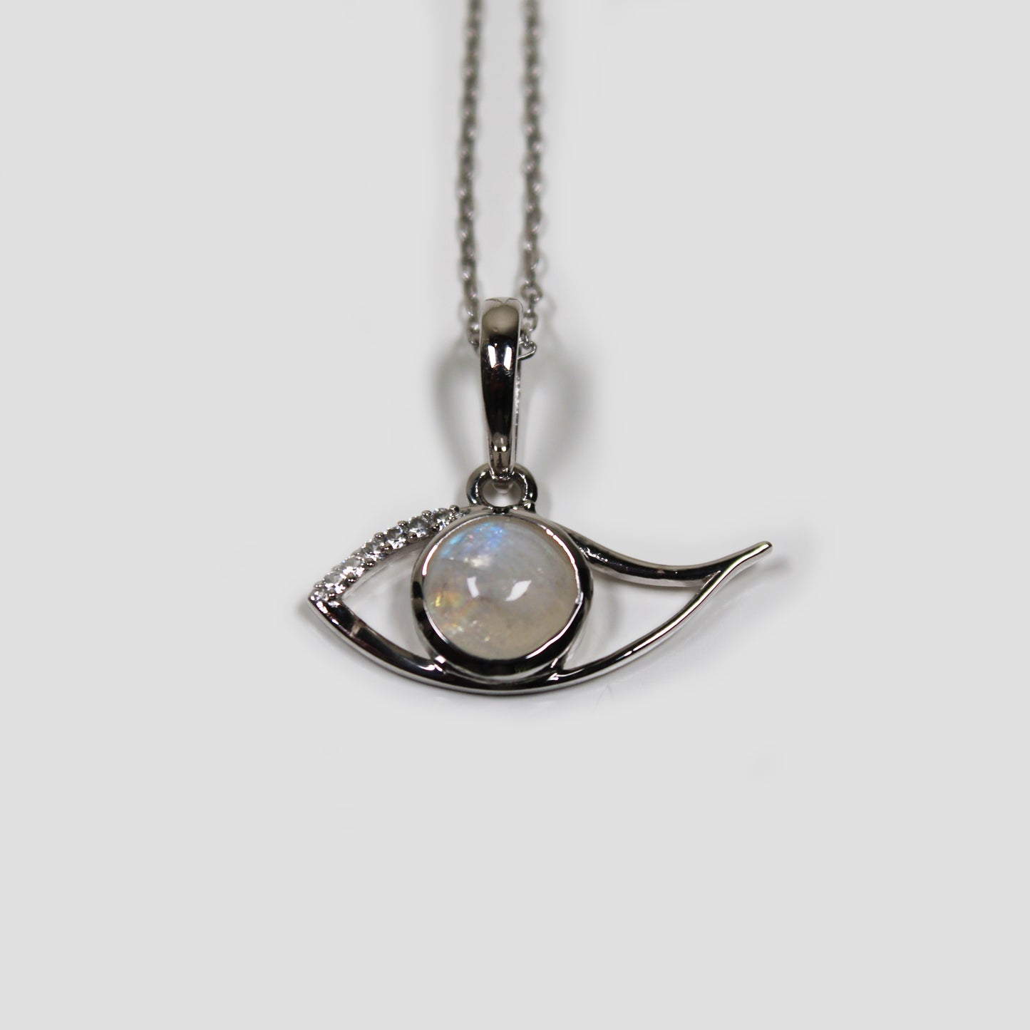 Moonstone Ra Eye with White Topaz on a gray surface