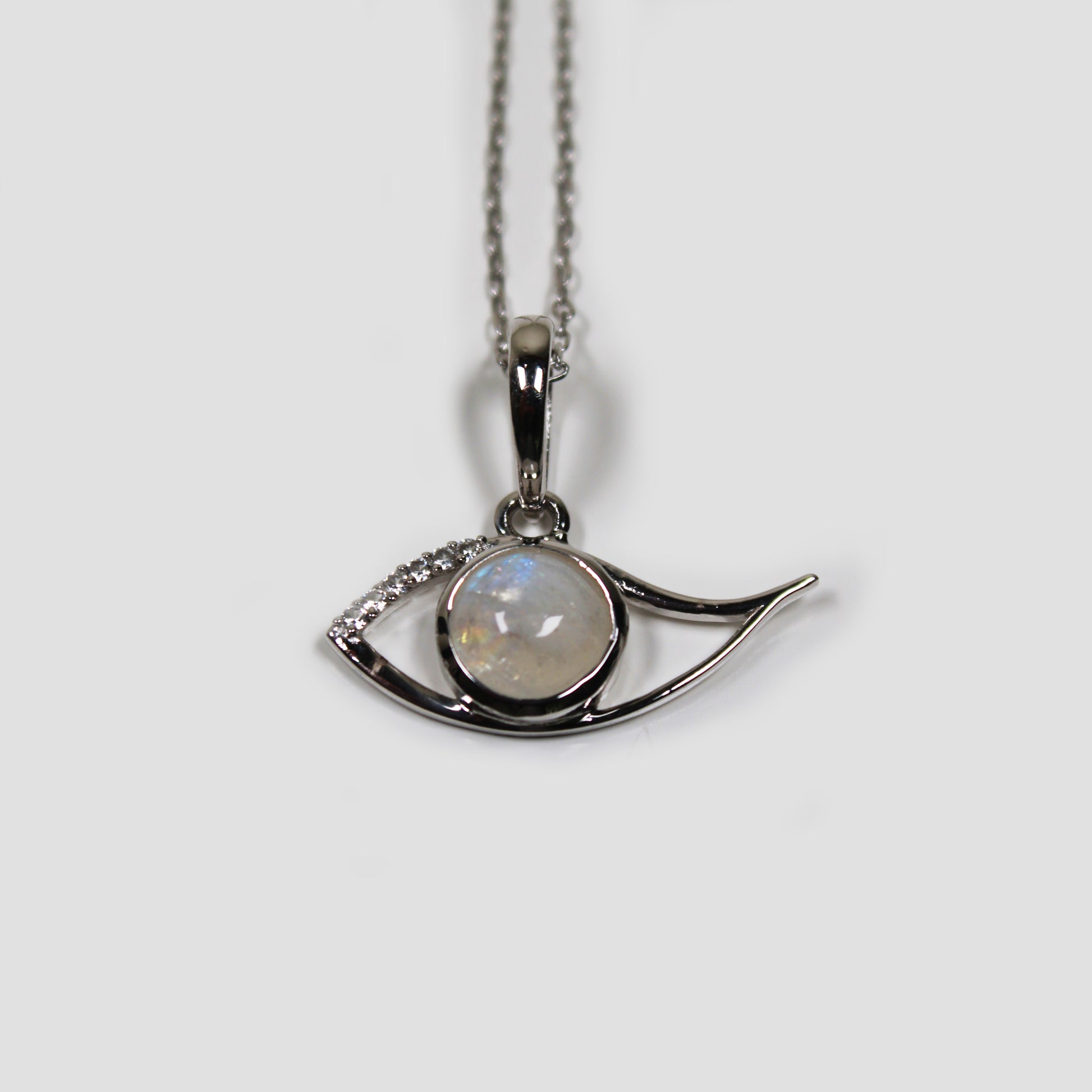 Moonstone Ra Eye with White Topaz on a gray surface