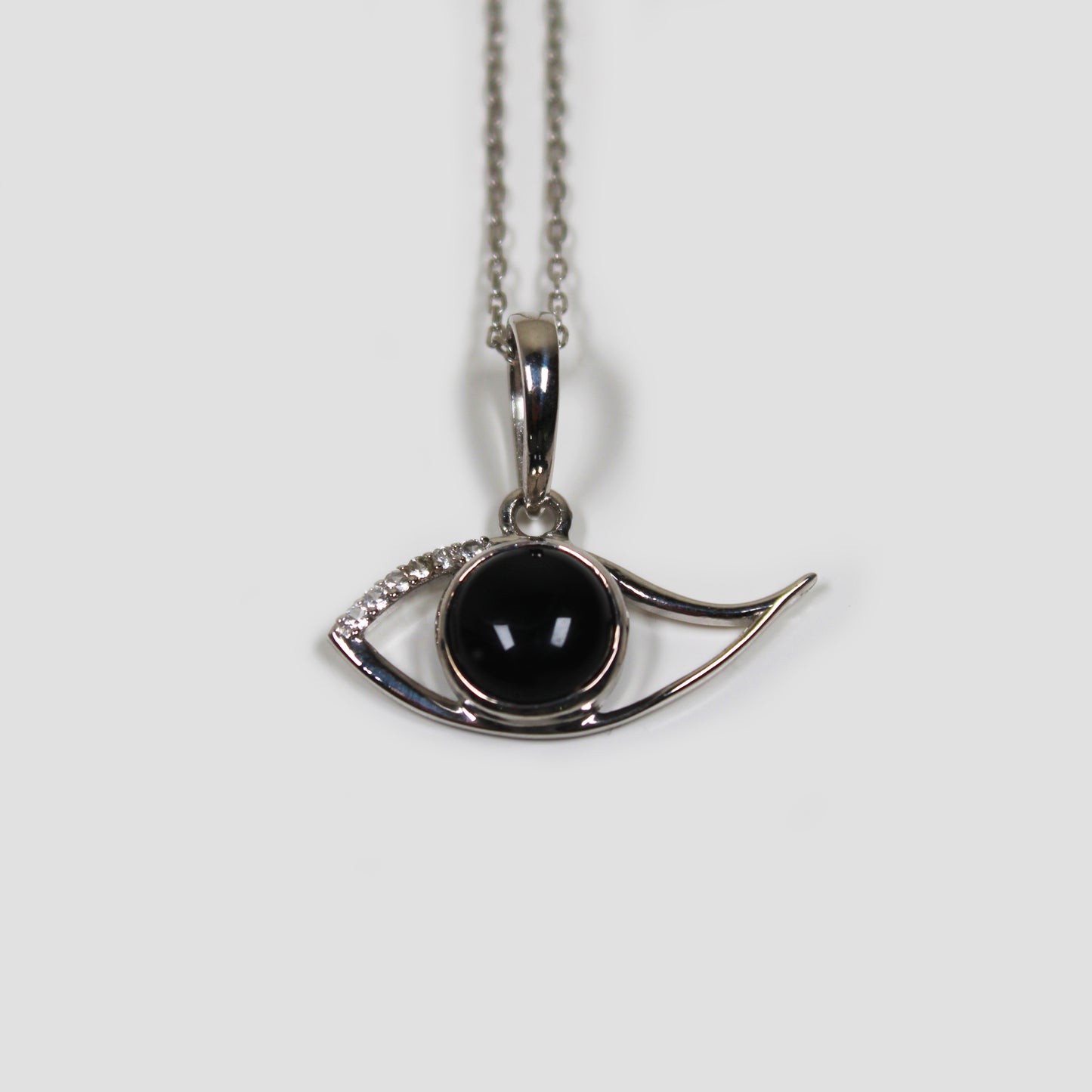 Black Onyx Ra Eye with White Topaz on a gray surface