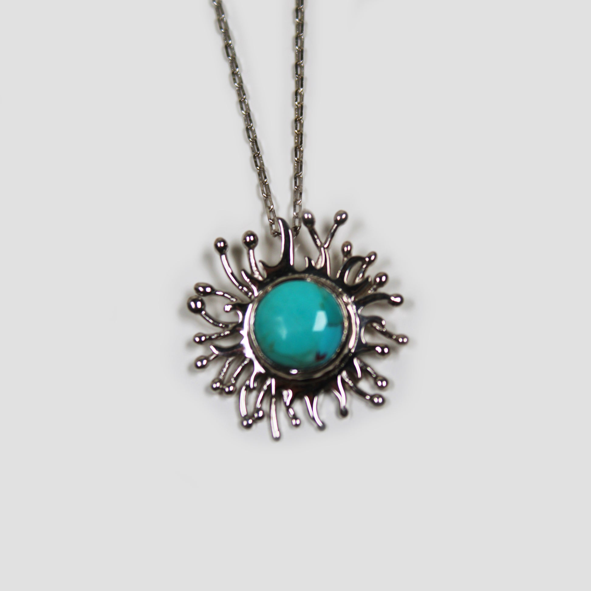 Turquoise Solaire Necklace on a gray surface