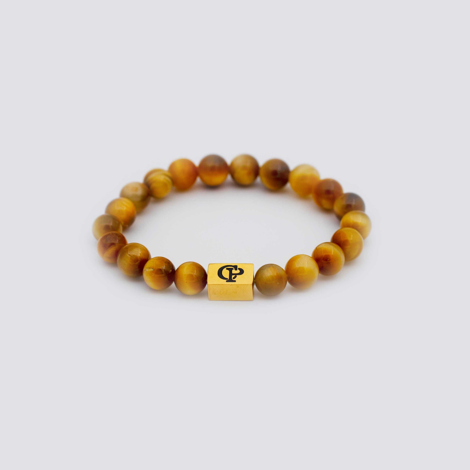 Orange Golden Tiger Eye Elastic Golden Bracelet on a gray surface