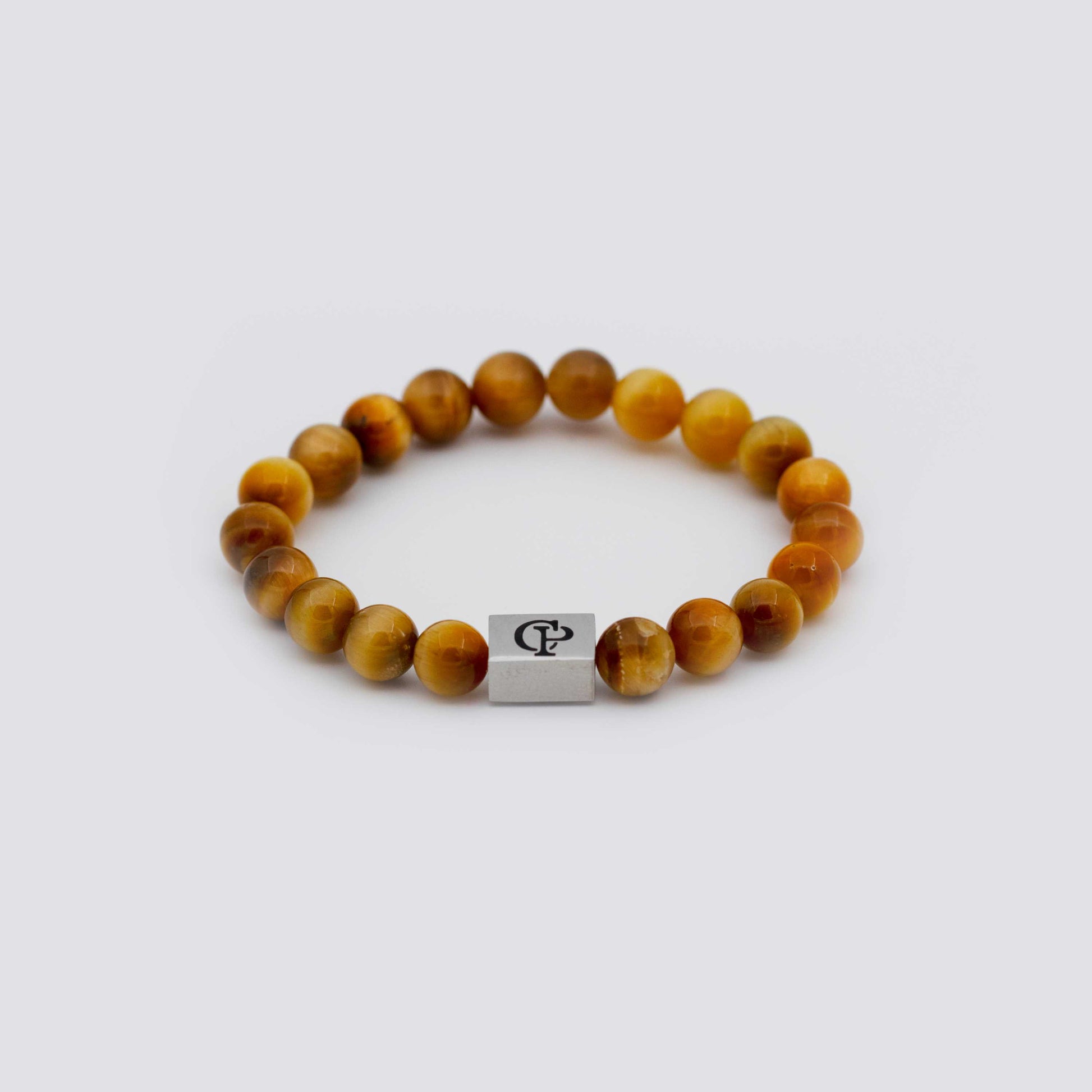 Orange Golden Tiger Eye Elastic Silver Bracelet on a gray surface