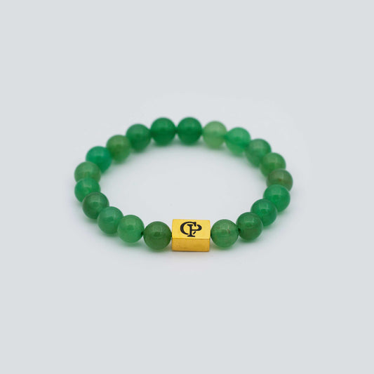 Green Aventurine Elastic Golden Bracelet on a gray surface