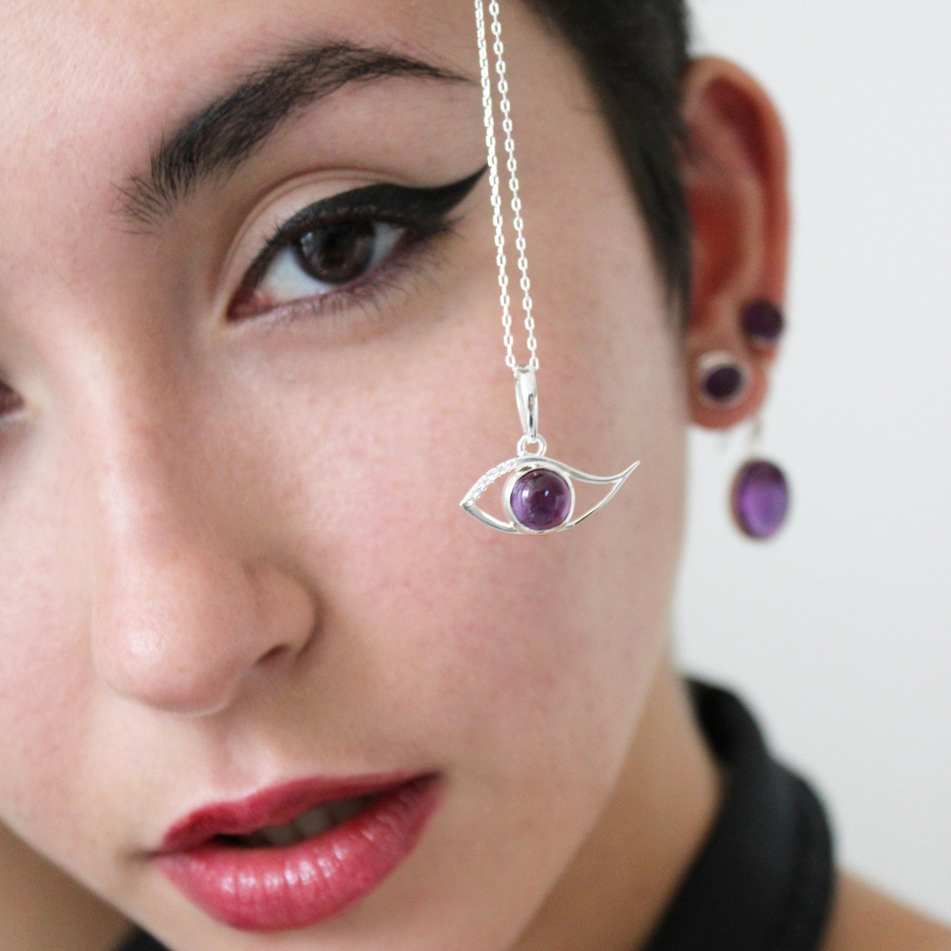 A woman holding Amethyst Ra Eye with White Topaz