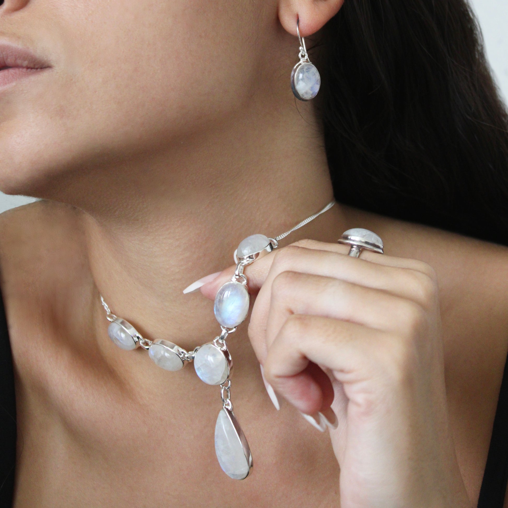 A woman wearing Moonstone Silver Earrings and Necklace 