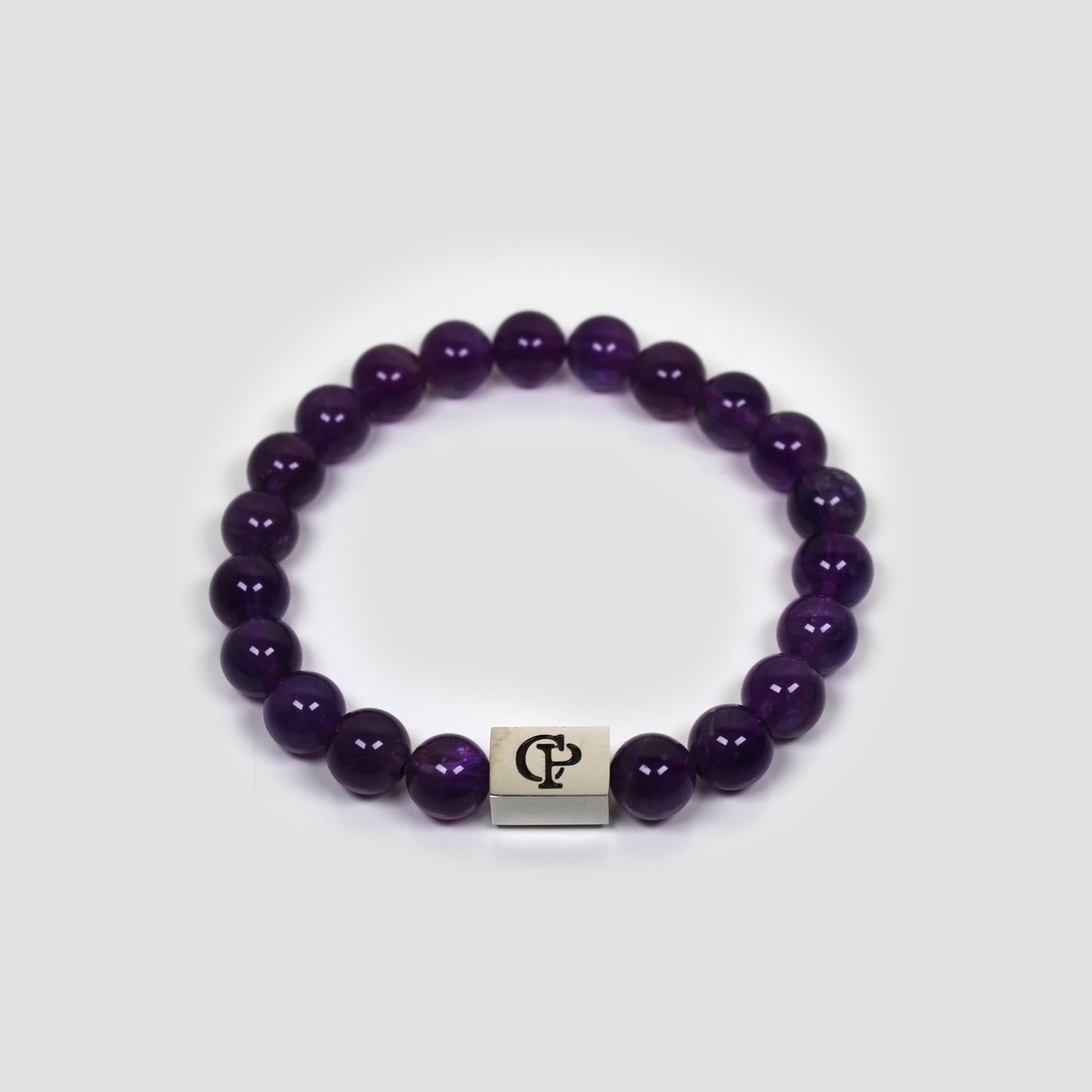 Purple Amethyst bracelet on a gray surface.