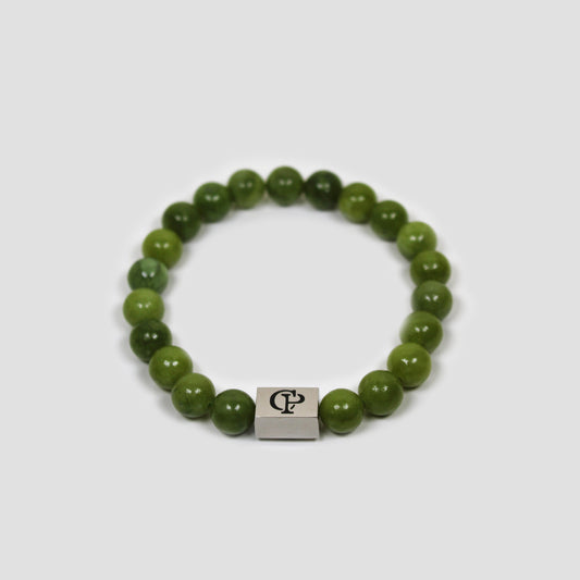 Canadian Green Jade Elastic Silver Bracelet on a gray surface
