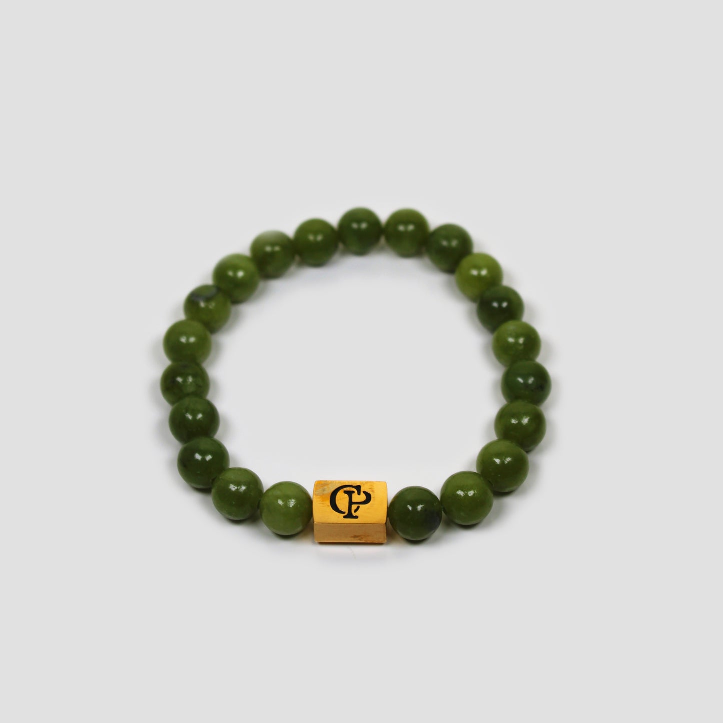 Canadian Green Jade Elastic Golden Bracelet on a gray surface