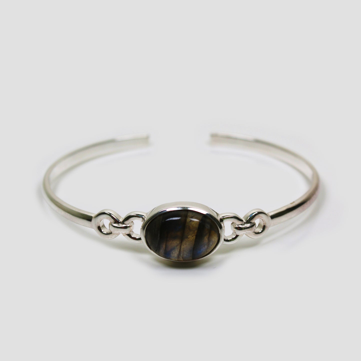 Green Labradorite Adjustable Silver Bangle on a gray surface