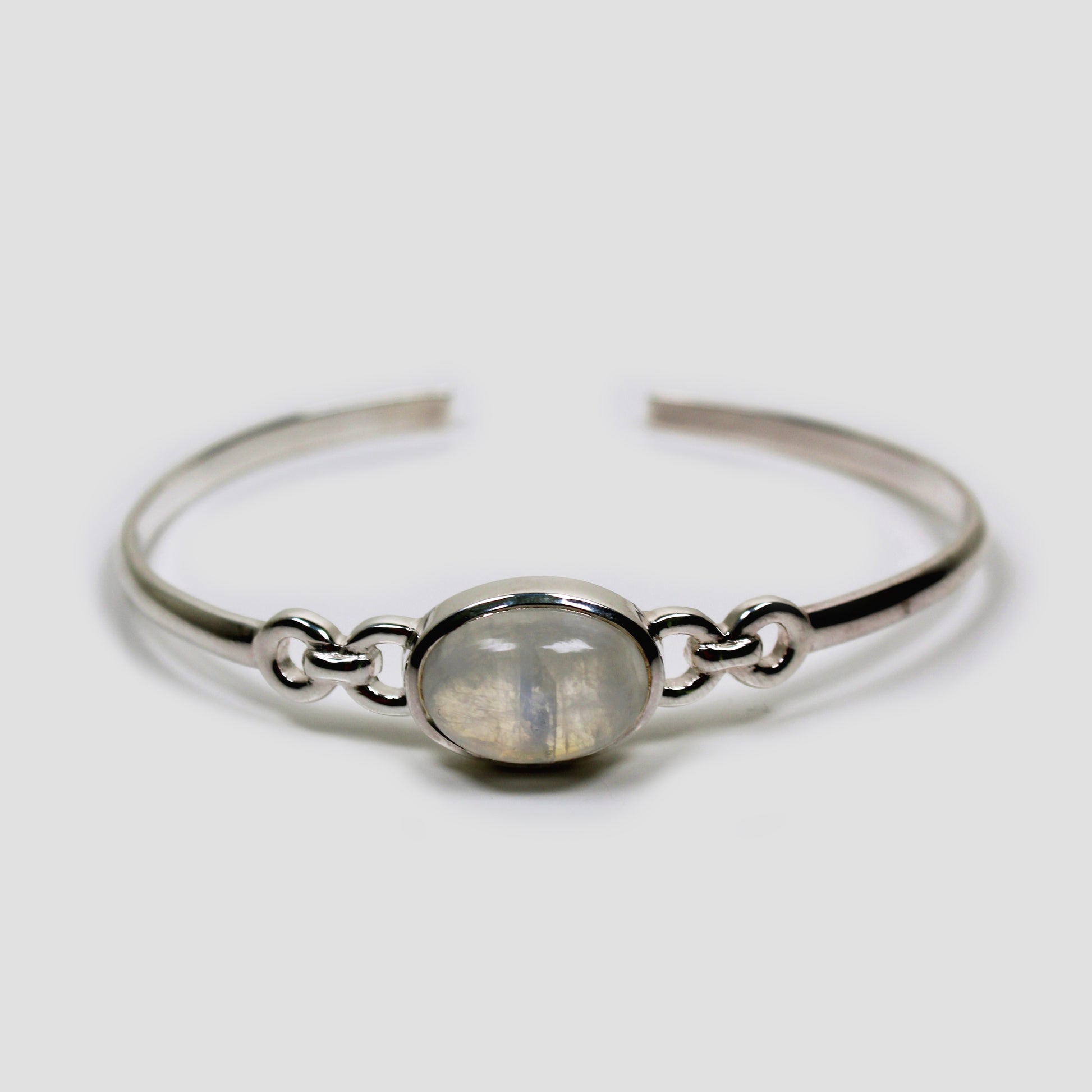 White Moonstone Adjustable Silver Bangle on a gray surface