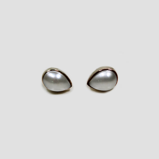 White Pearl Stud Earrings on a gray surface