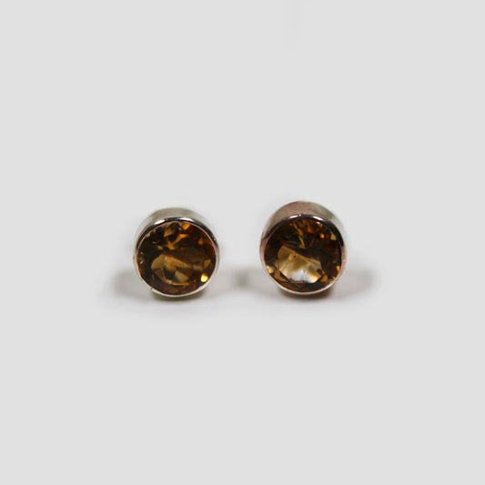 Yellow Citrine Cut Stud Earrings on a gray surface