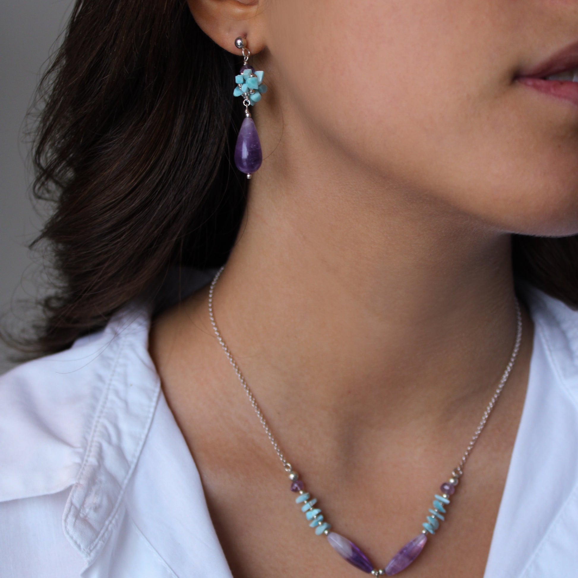 A woman wearing Larimar & Amethyst Earrings and Necklace 