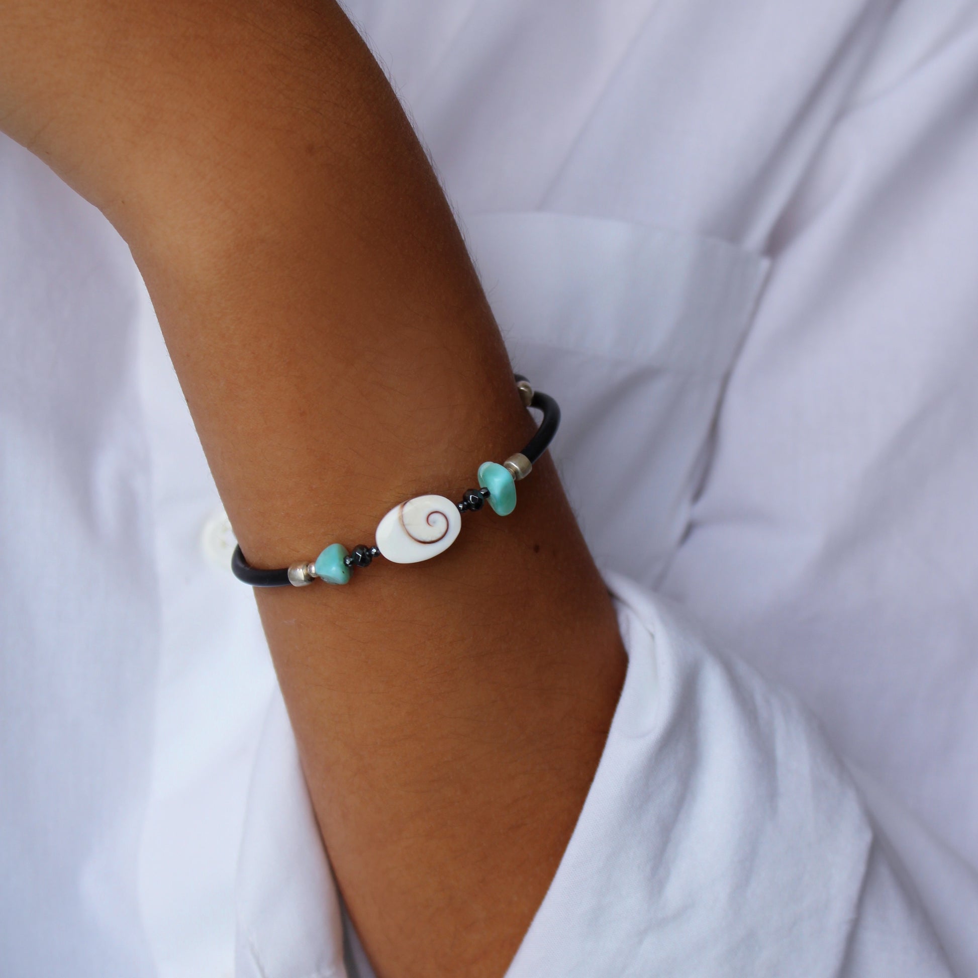 A woman wearing Larimar Hematite Shiva Eye Bracelet