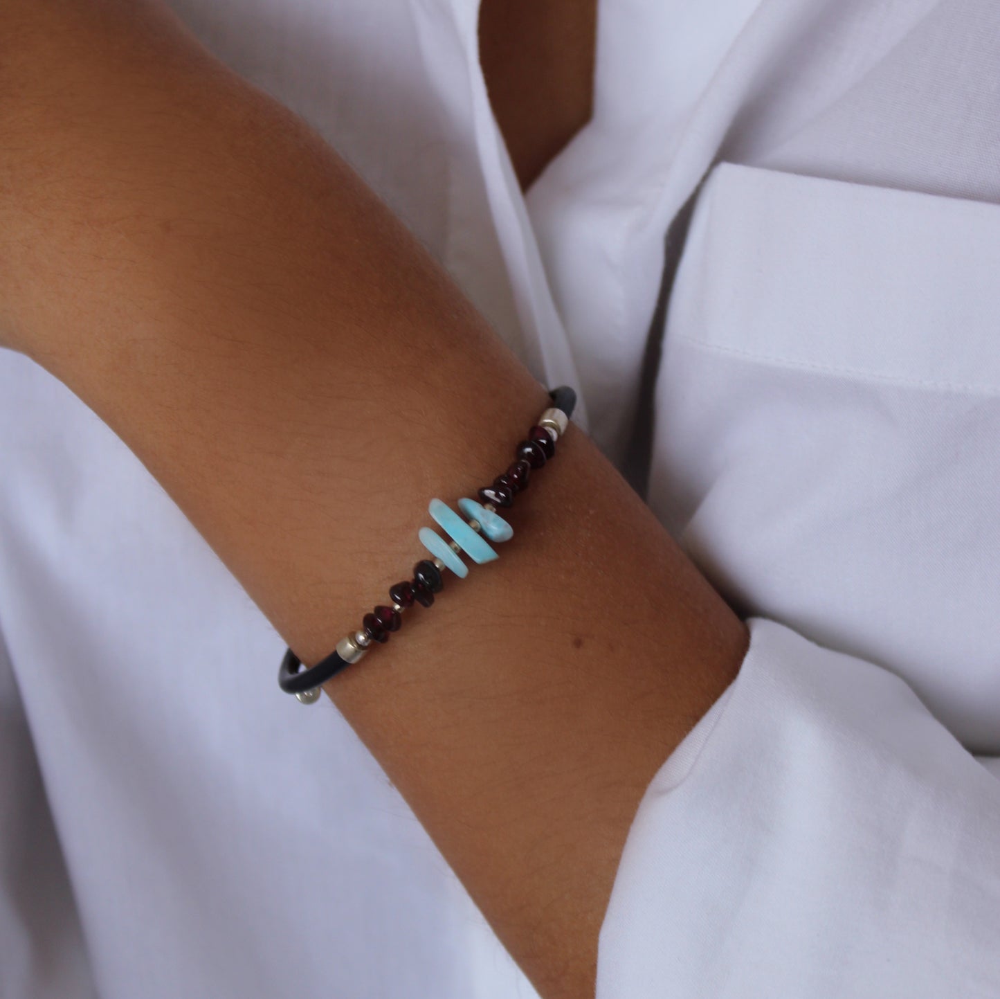 A woman wearing Larimar Garnet Leather Cord Bracelet on her wrist