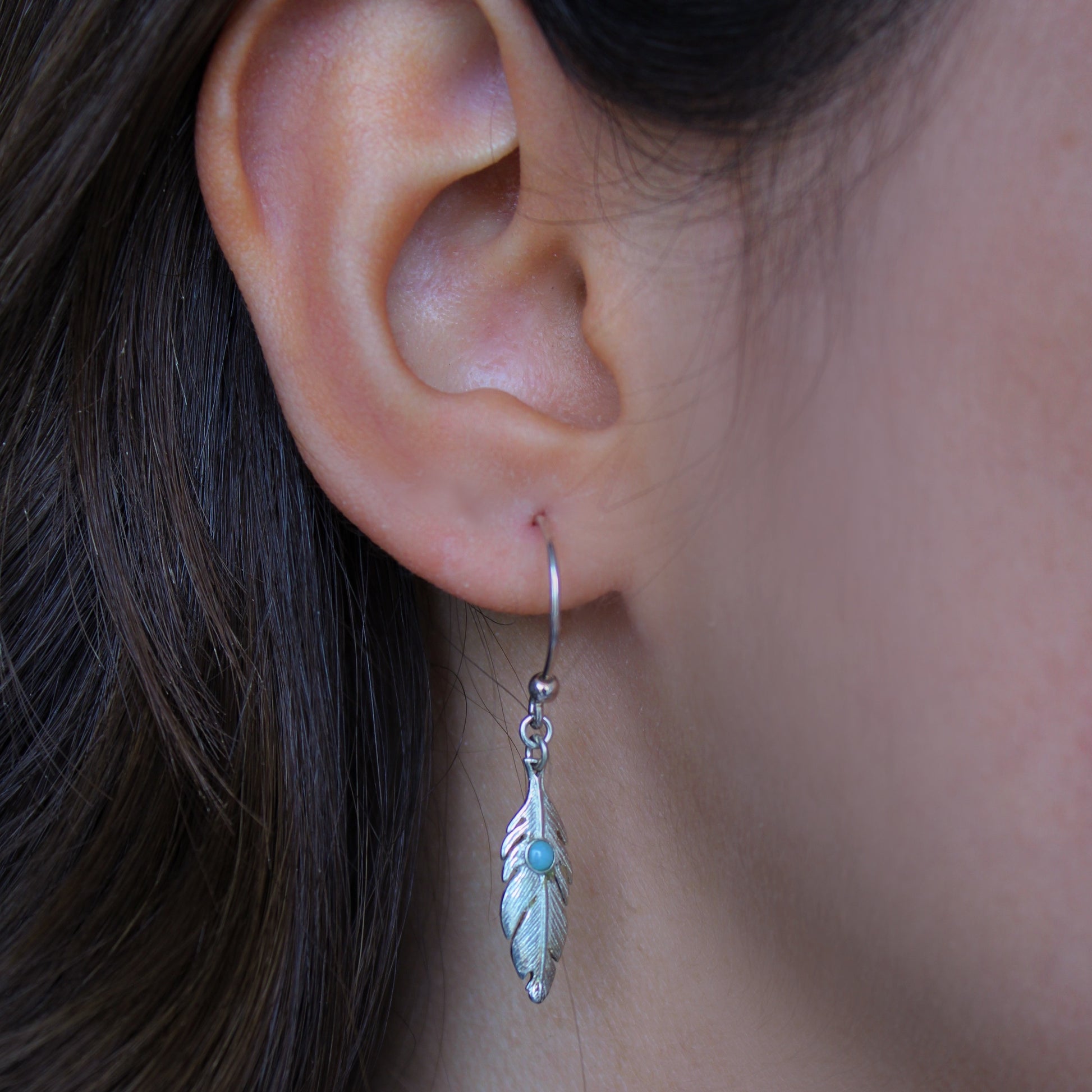 A woman wearing Larimar Feather Silver Earrings