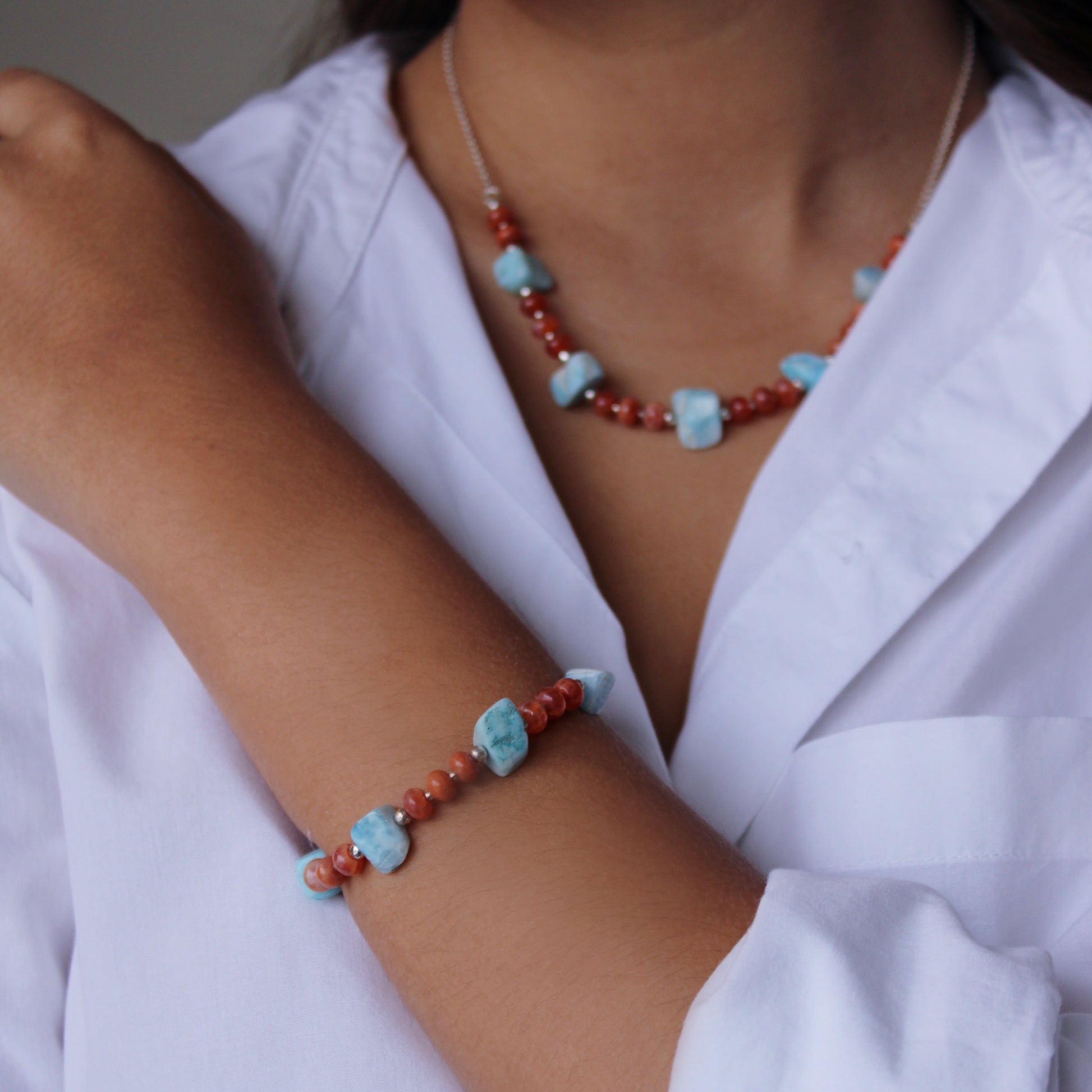 A woman wearing Larimar & Carnelian Bracelet and Necklace