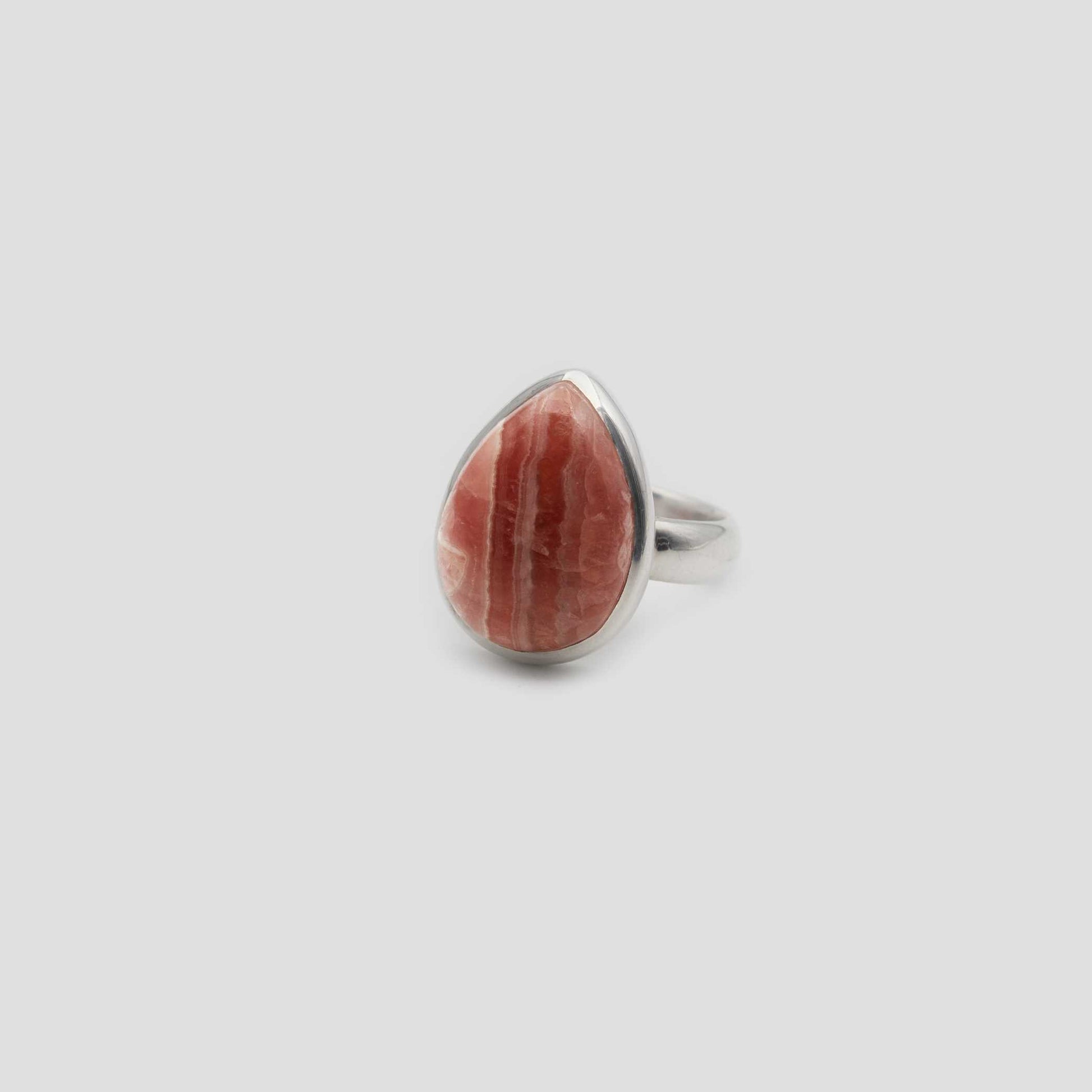 Rose Rhodochrosite Silver Tear drop Ring a gray surface